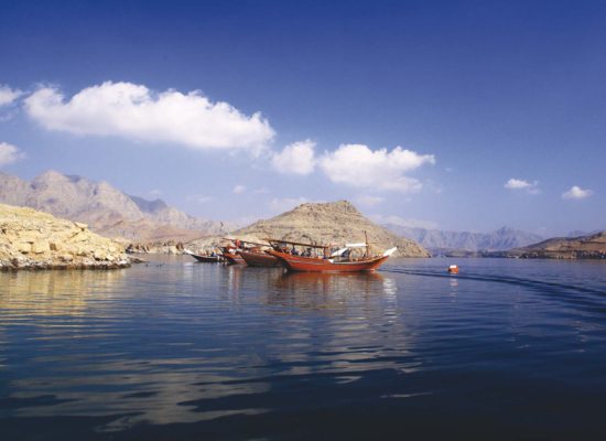 A Dhow Cruise is docked at the Musandam sea with nice clouds and clear blue water